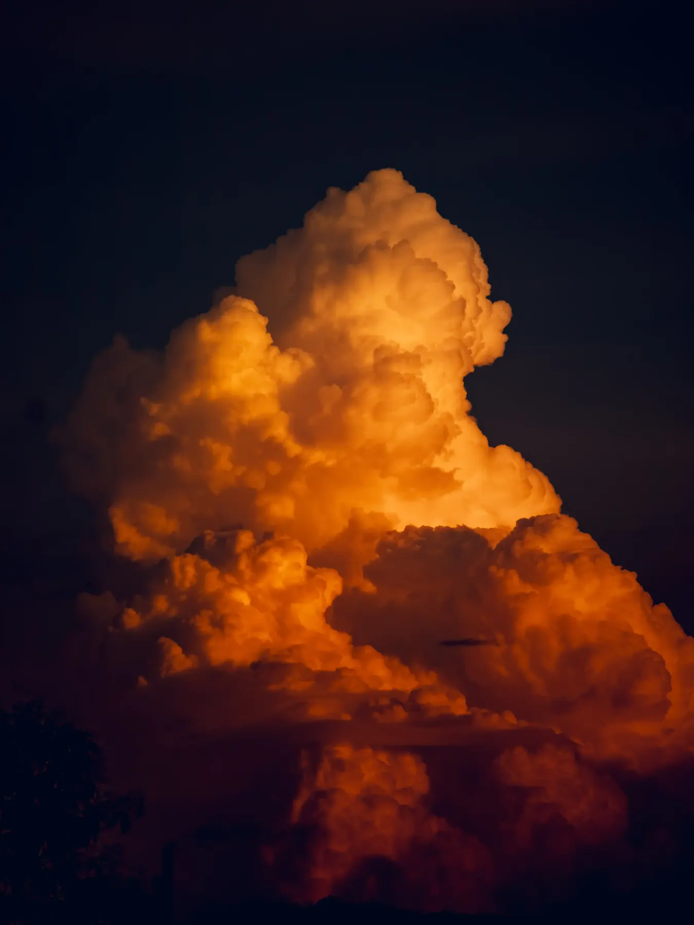 A glowing orange storm cloud against a dark sky