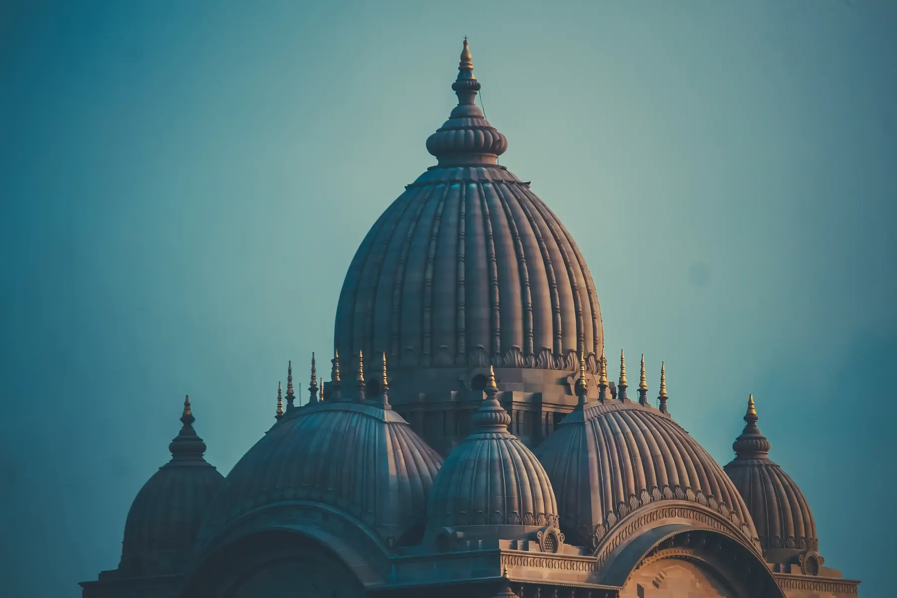 A terracotta domed temple against a blue sky
