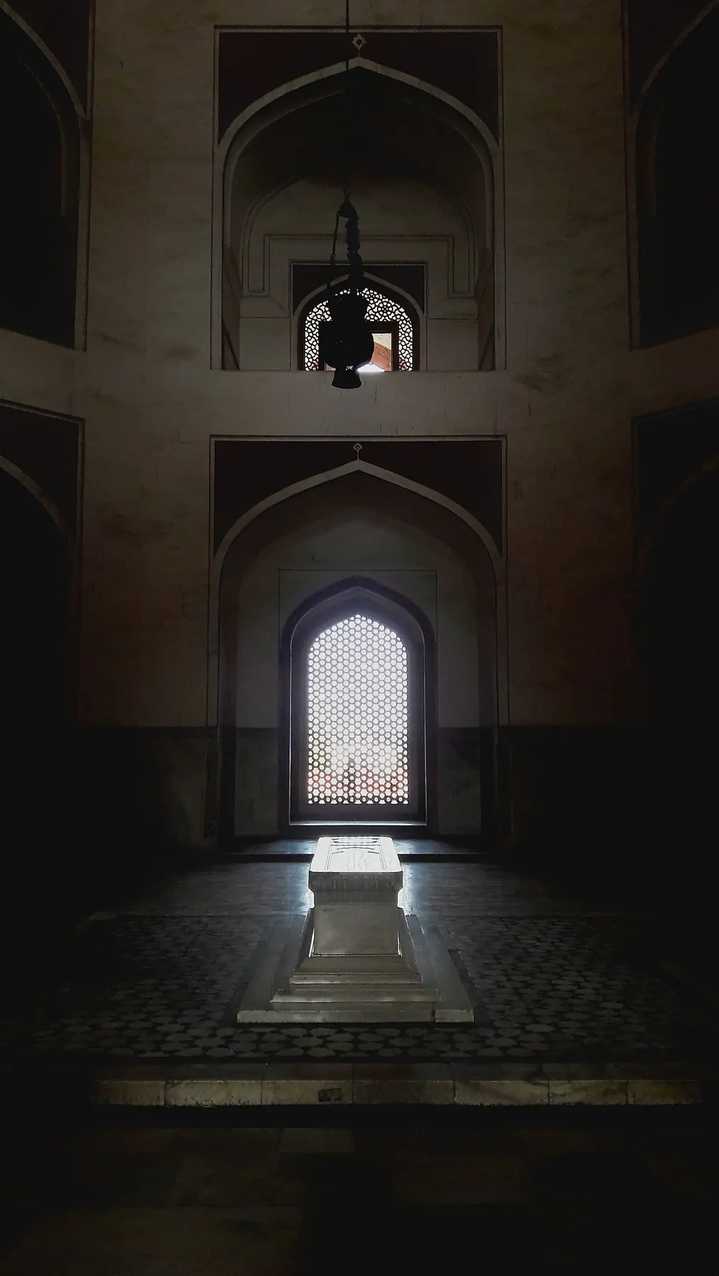 An archway leading toward a lit doorway